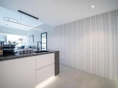 a kitchen with white cabinets and a black counter top at Stylish Upgraded 1 Bedroom Marina Escape in Dubai