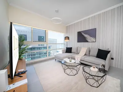 a living room with a couch and a large window at Stylish Upgraded 1 Bedroom Marina Escape in Dubai