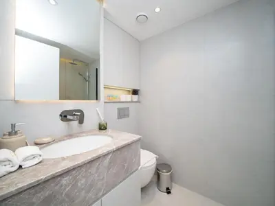 a bathroom with a sink and a toilet and a mirror at Stylish Upgraded 1 Bedroom Marina Escape in Dubai