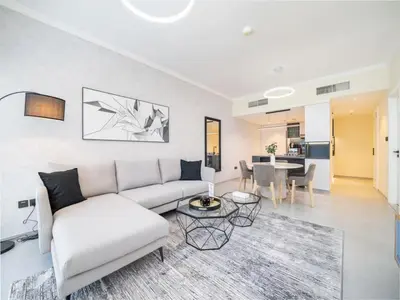 a living room with a white couch and a table at Stylish Upgraded 1 Bedroom Marina Escape in Dubai