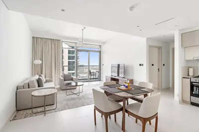 a dining room and living room with a table and chairs at Silkhaus Sea View 1BDR Exclusive Tower Beach in Dubai