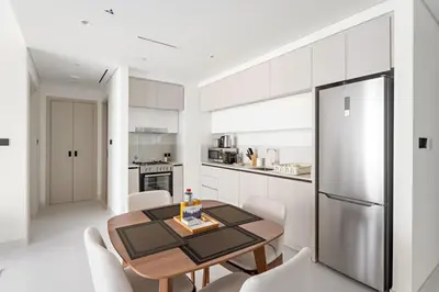 a kitchen with a table and chairs and a refrigerator at Silkhaus Sea View 1BDR Exclusive Tower Beach in Dubai