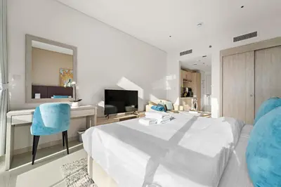 a bedroom with a bed and a desk and a television at Stonetree - Brand New Studio - Prime Location in Dubai