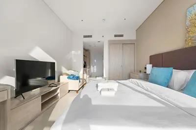 a bedroom with a large bed and a television at Stonetree - Brand New Studio - Prime Location in Dubai
