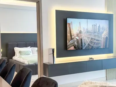 a living room with a flat screen tv on a wall at High Floor Burj Khalifa View 1BR - Business Bay in Dubai