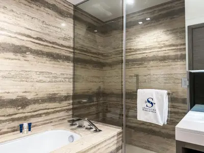 a bathroom with a tub and a glass shower at High Floor Burj Khalifa View 1BR - Business Bay in Dubai