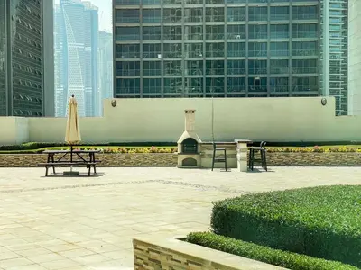 a table and an umbrella in a courtyard with buildings at Spacious 2BR in Downtown in High Floor in Dubai