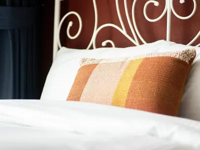 a bed with a brown and yellow pillow on it at Spacious 2BR in Downtown in High Floor in Dubai