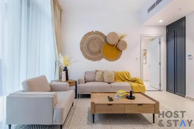 a living room with a couch and a table at Central 1BR Apartment at Wilton Park - Host & Stay in Dubai