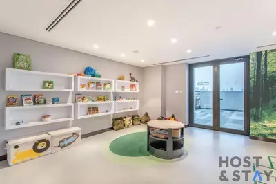 a childs room with white shelves and a table at Central 1BR Apartment at Wilton Park - Host & Stay in Dubai