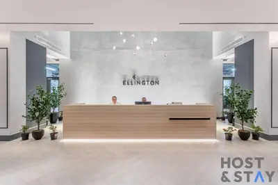 two people sitting at a reception desk in a lobby at Central 1BR Apartment at Wilton Park - Host & Stay in Dubai