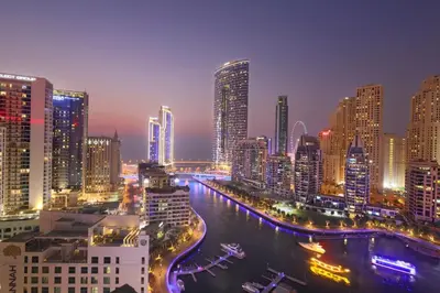 a city skyline at night with a river and buildings at Condor Marina Star, Dubai Marina by SIMPLY COMFORT in Dubai
