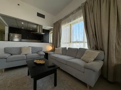 a living room with a couch and a table at Ashri HH, Studio in Dana Tower in Dubai