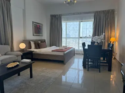 a living room with a bed and a couch and a table at Ashri HH, Studio in Dana Tower in Dubai