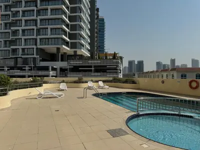 a swimming pool with lounge chairs and a building at Ashri HH, Studio in Dana Tower in Dubai