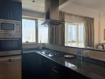 a kitchen with a stove and a microwave at Ashri HH, Studio in Dana Tower in Dubai