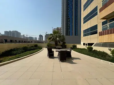 a patio with a table and chairs in front of a building at Ashri HH, Studio in Dana Tower in Dubai