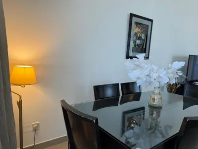 a dining room table with a vase of flowers on it at Ashri HH, Studio in Dana Tower in Dubai