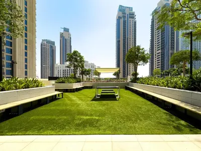a park with grass and benches in a city at Globalstay Creek Horizon Modern Apartments in Dubai