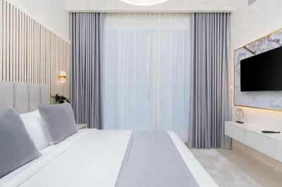 a bedroom with a large white bed and a flat screen tv at Globalstay Creek Horizon Modern Apartments in Dubai