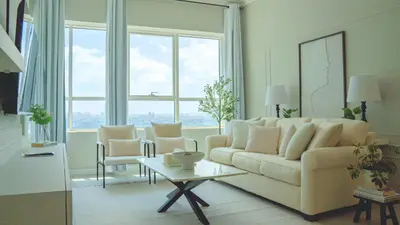 a living room with a couch and a table at Spacious 1BR, Pool, Gym, Near Dining & Shops in Dubai