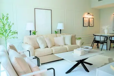 a living room with a couch and a table at Spacious 1BR, Pool, Gym, Near Dining & Shops in Dubai