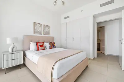 a bedroom with a large bed with white walls at 1BR with Park & Downtown Views plus Dubai Frame in Dubai