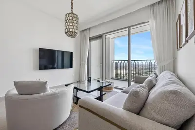a living room with a couch and a tv at 1BR with Park & Downtown Views plus Dubai Frame in Dubai