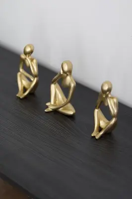 a pair of gold earrings sitting on a table at Shining studio in Laya Heights in Dubai