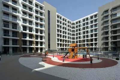 a playground in front of a large apartment building at Shining studio in Laya Heights in Dubai