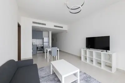 a living room with a couch and a tv at Splendid 1BR in Living Garden in Dubai