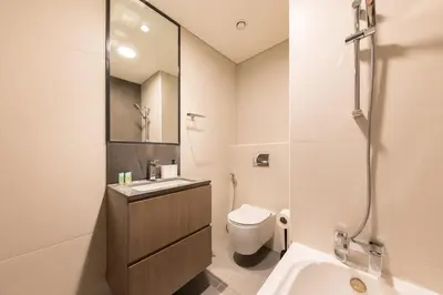 a white bathroom with a sink and a toilet at Splendid 1BR in Living Garden in Dubai
