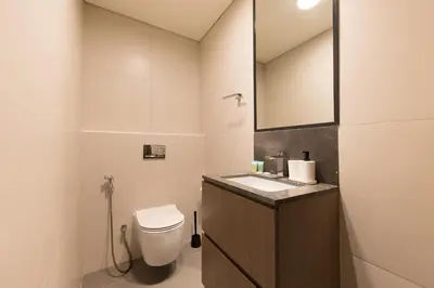 a bathroom with a toilet and a sink and a mirror at Splendid 1BR in Living Garden in Dubai