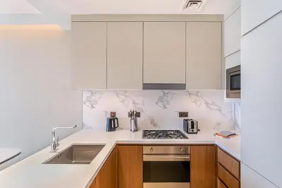 a kitchen with white cabinets and a sink at Address Dubai Opera Residences by The S Holiday Homes in Dubai
