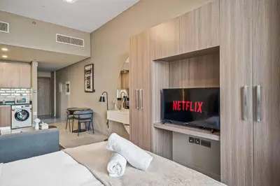 a bedroom with a bed with a tv in a cabinet at Peacefull Studio - Arjan in Dubai