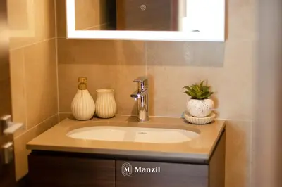 a bathroom sink with two vases on top of it at Manzil - 1BR Apartment in Sobha Hartland with City Views in Dubai