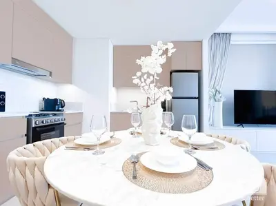 a white dining room table with glasses and a vase with flowers at Amazing stay at Dubai creek with Balcony & View in Dubai