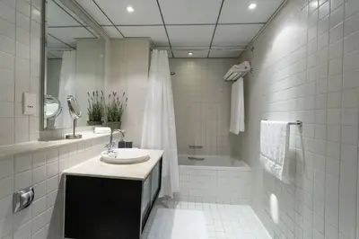 a white tiled bathroom with a sink and a tub at Dubai Marina Walking distance to metro Marina View in Dubai