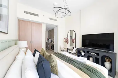 a living room with a white couch and a television at Silkhaus Luxurious Studio in High End Neighborhood in Dubai