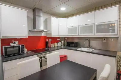 a kitchen with white cabinets and a table with a microwave at Ideal for Families Close to ALL Amenities in Dubai