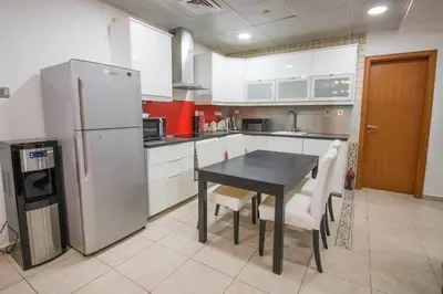 a kitchen with a black table and a refrigerator at Ideal for Families Close to ALL Amenities in Dubai