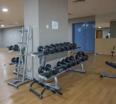 a gym with several racks of weights in a room at Ideal for Families Close to ALL Amenities in Dubai