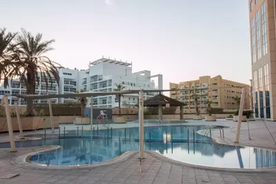 a large swimming pool in a city with buildings at Ideal for Families Close to ALL Amenities in Dubai