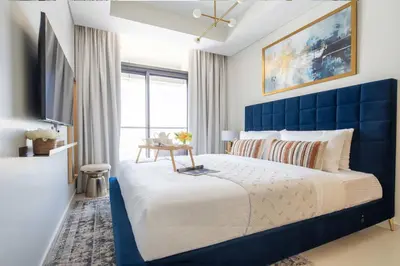 a blue bedroom with a large bed with a blue headboard at Frank Porter - Aykon City Tower in Dubai
