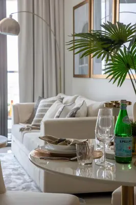 a living room with a couch and a table with wine glasses at Frank Porter - Aykon City Tower in Dubai