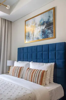 a bed with a blue headboard in a room at Frank Porter - Aykon City Tower in Dubai