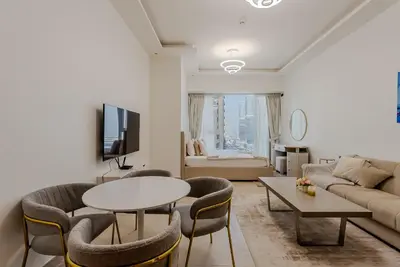 a living room with a table and chairs and a couch at Cozy Studio in JLT I Medore in Dubai