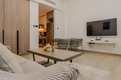 a living room with a coffee table and a tv at Cozy Studio in JLT I Medore in Dubai