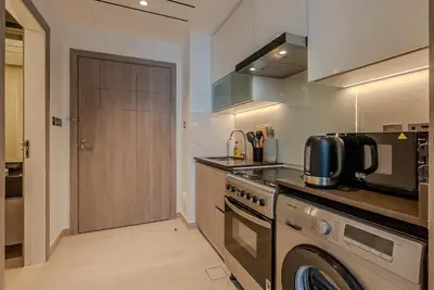 a kitchen with a stove and a washer and dryer at Cozy Studio in JLT I Medore in Dubai