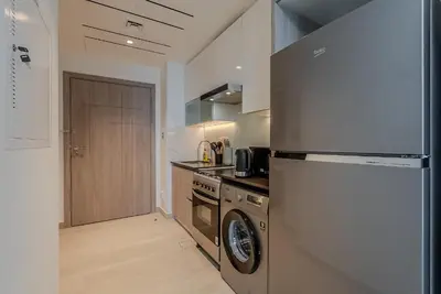 a kitchen with a stainless steel refrigerator and a dishwasher at Cozy Studio in JLT I Medore in Dubai
